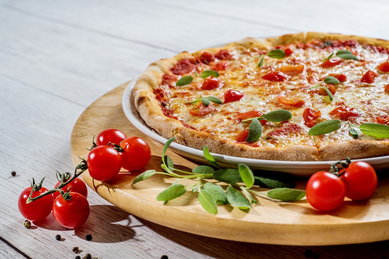 Table spread with several pizzas and sides